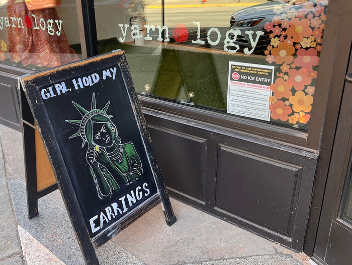 On chalkboard there's a drawing of the Statue of Liberty removing an earring, 