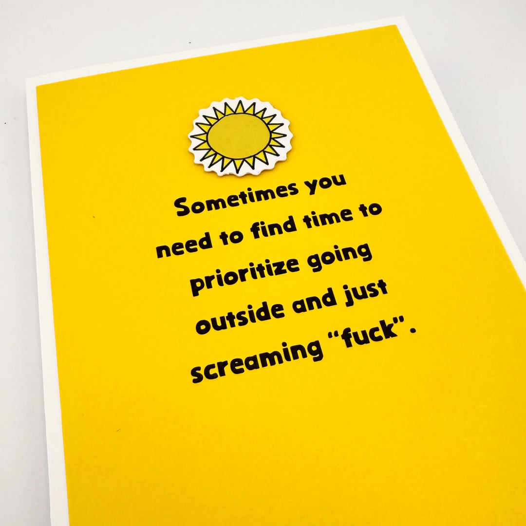 Yellow cut out sun on a Yellow card that says, "Sometimes you need to find time to prioritize going outside and just screaming 'fuck".