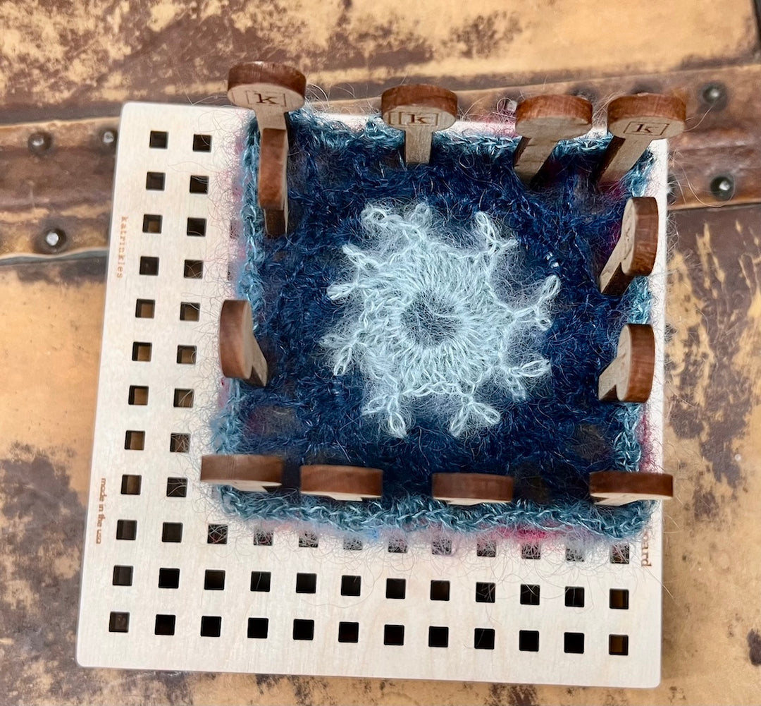 Top view of a stack of granny squares being blocked.