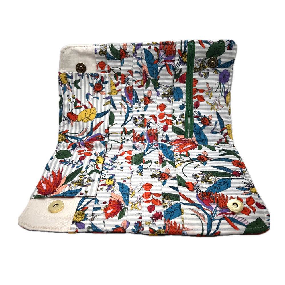 Inside of needle pouch with a vibrant multicolor floral print on a white striped background..