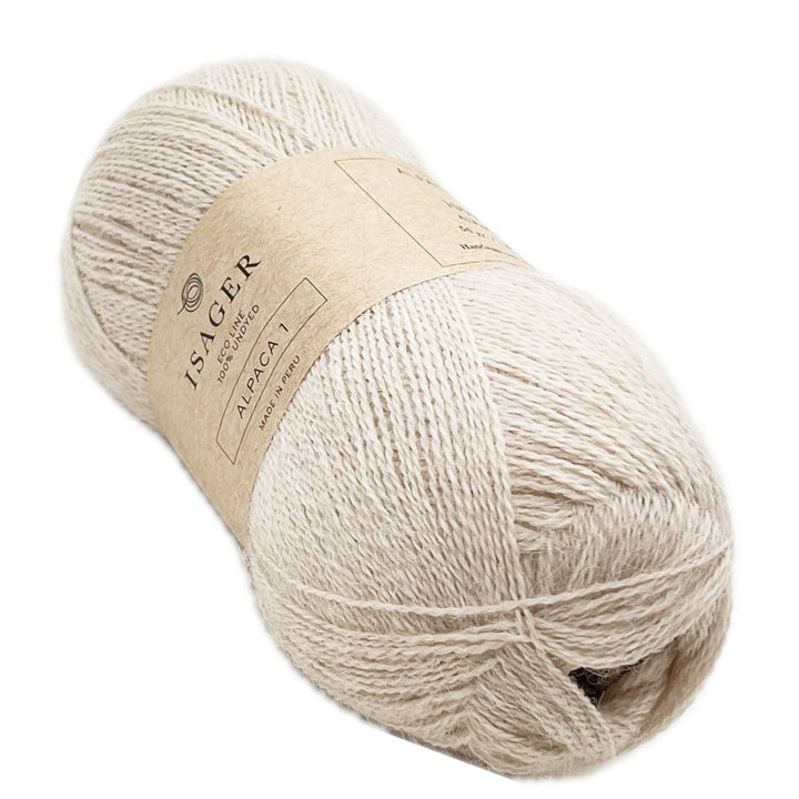 A skein of undyed yarn that's color is cream with warm hues. 