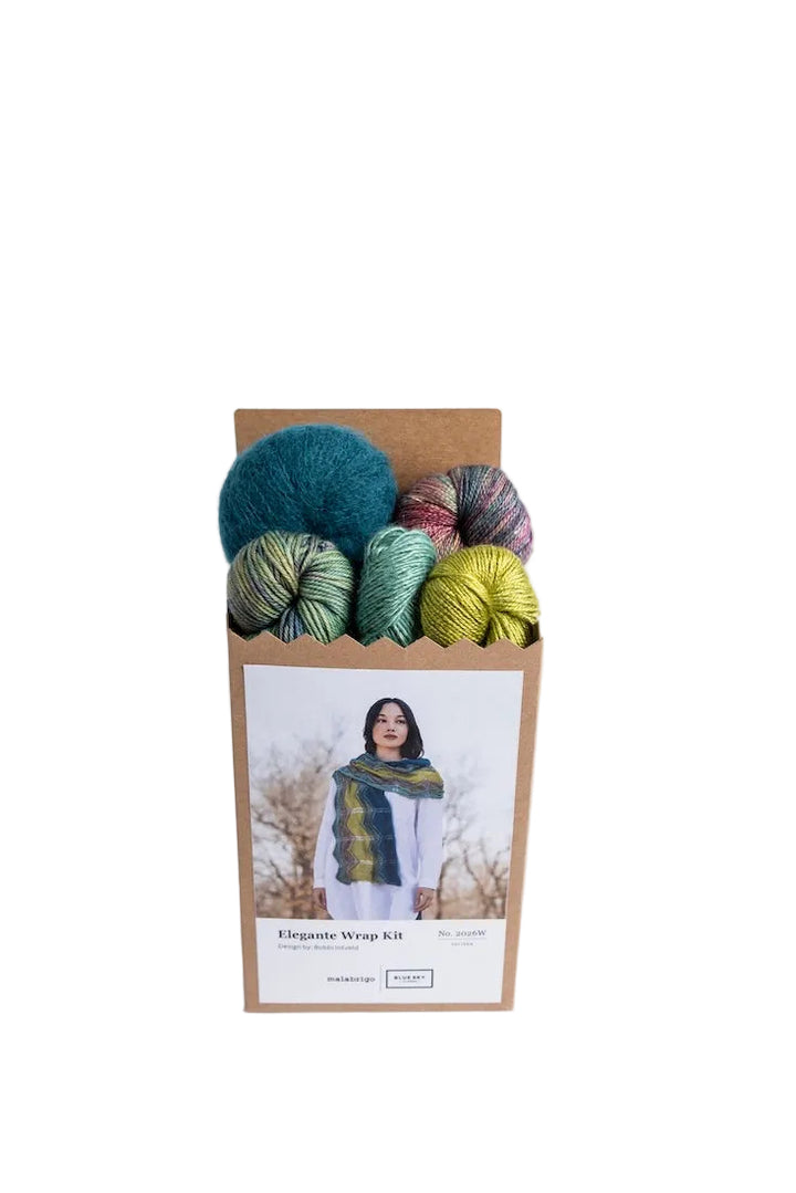 5 skeins of yarn (soft teal, variegated reds, variegated greens, sage, and goldenrod) in a box showing an image of the Elegant Wrap pattern on it.