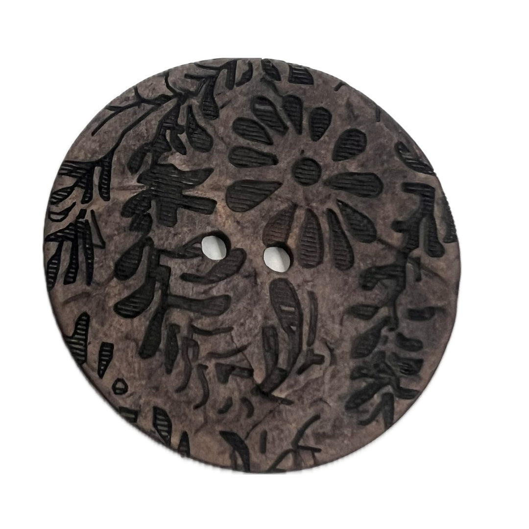 2 holed button with fauna carved on it's face.
