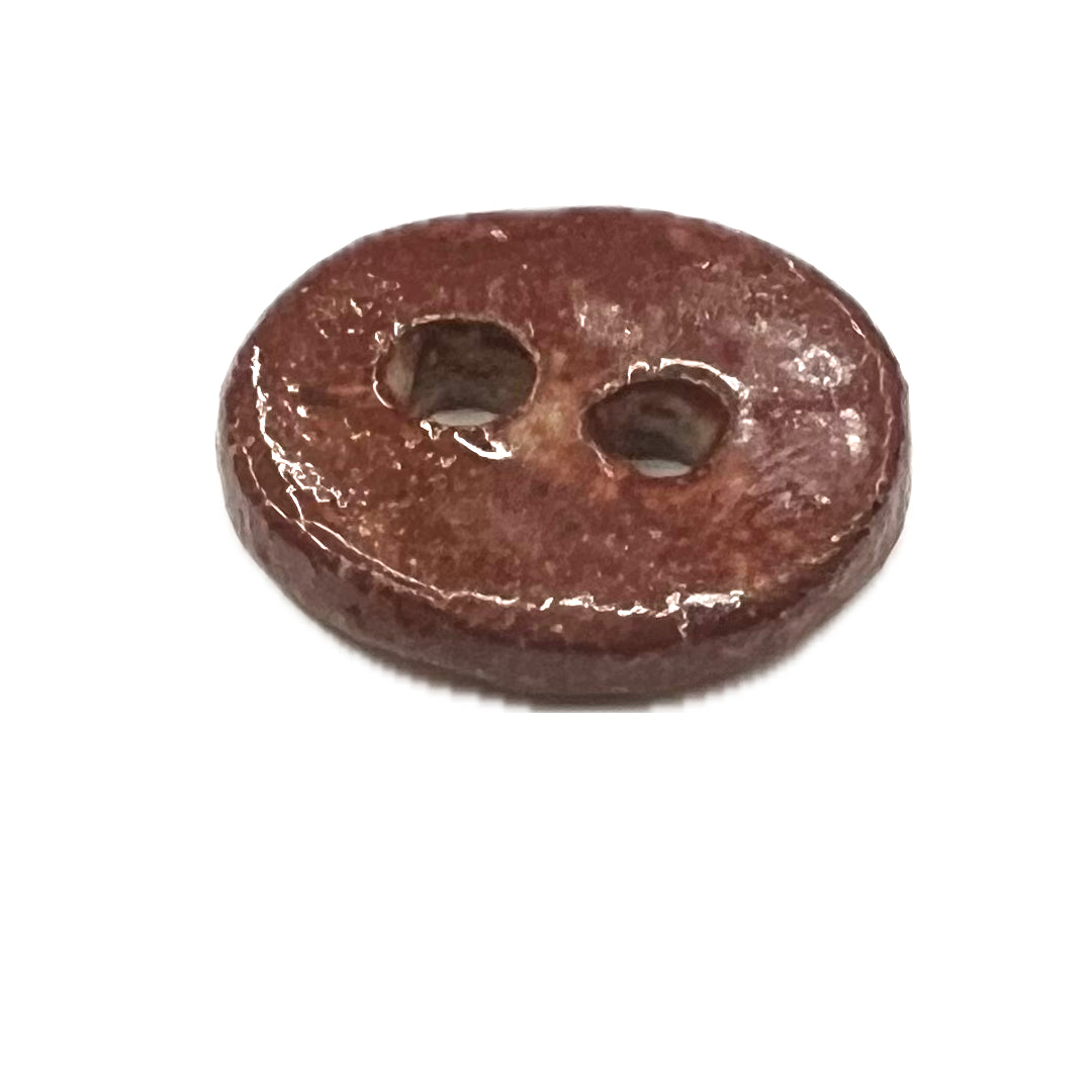 Round ceramic button with 2 holes.