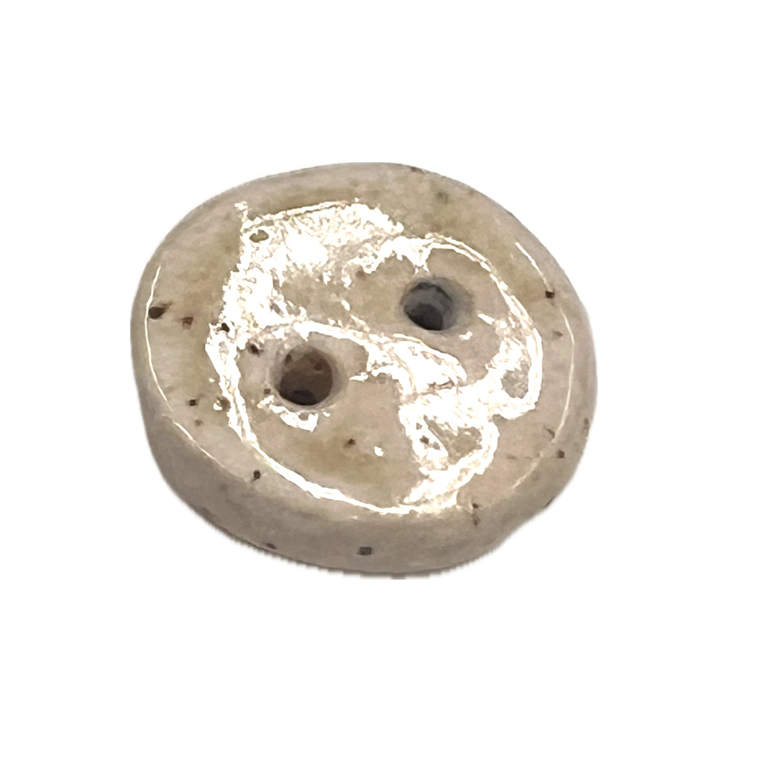 Imperfectly round button with 2 holes.