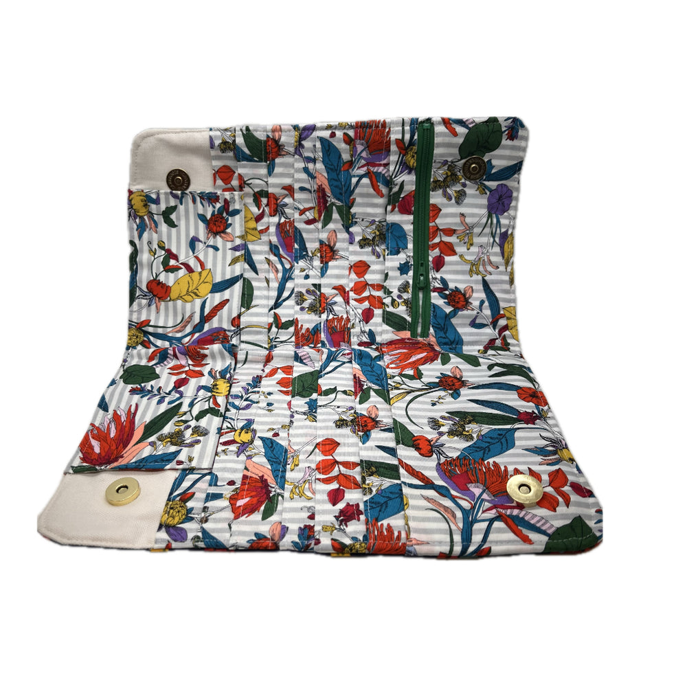 Inside of a the needle organizer with a vibrant multicolor floral and bird print on a white background, featuring  a green zipper pull.