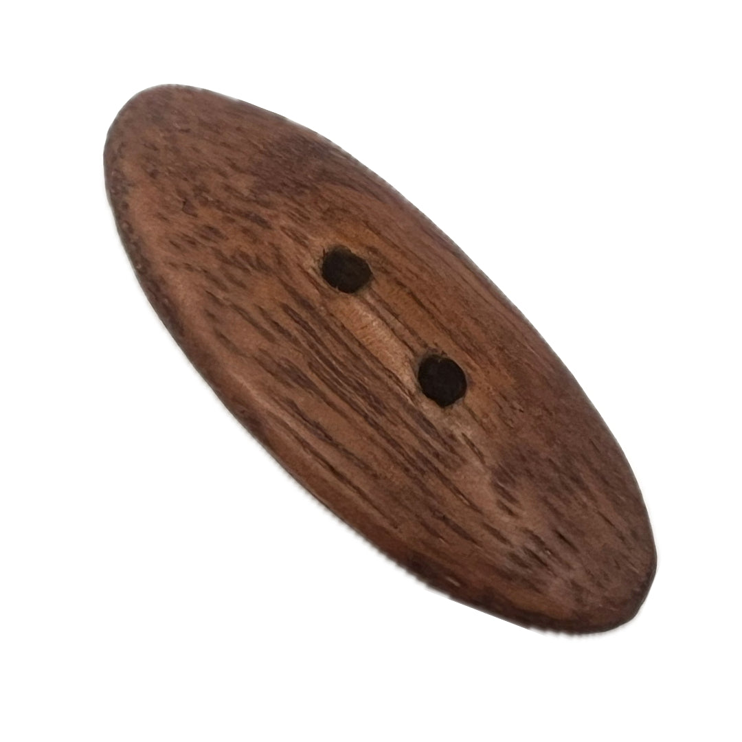 Long oval button made from Hormigo wood with 2 holes.