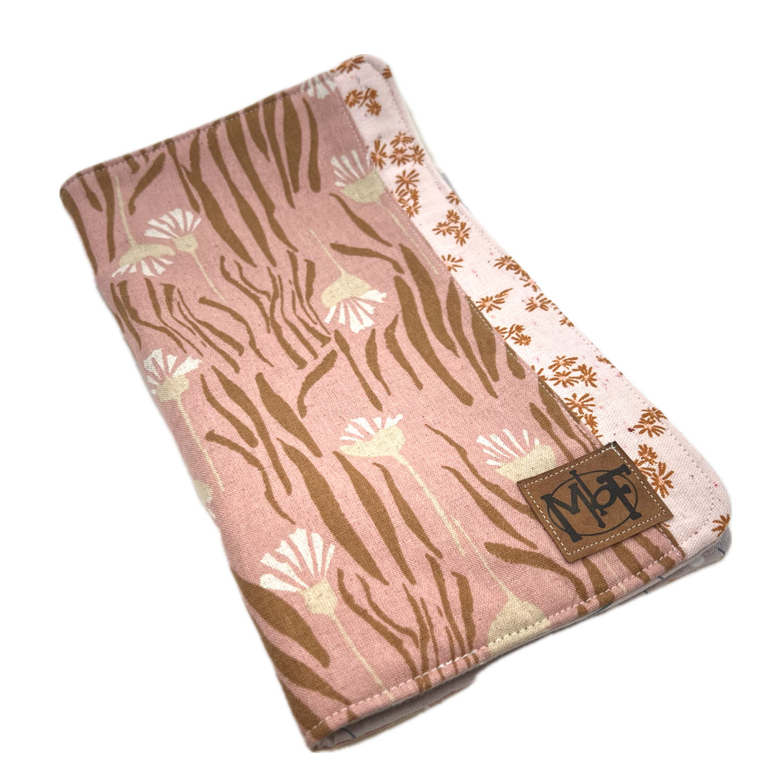 Front of the needle organizer in pink with beige flowers and brown leaves.