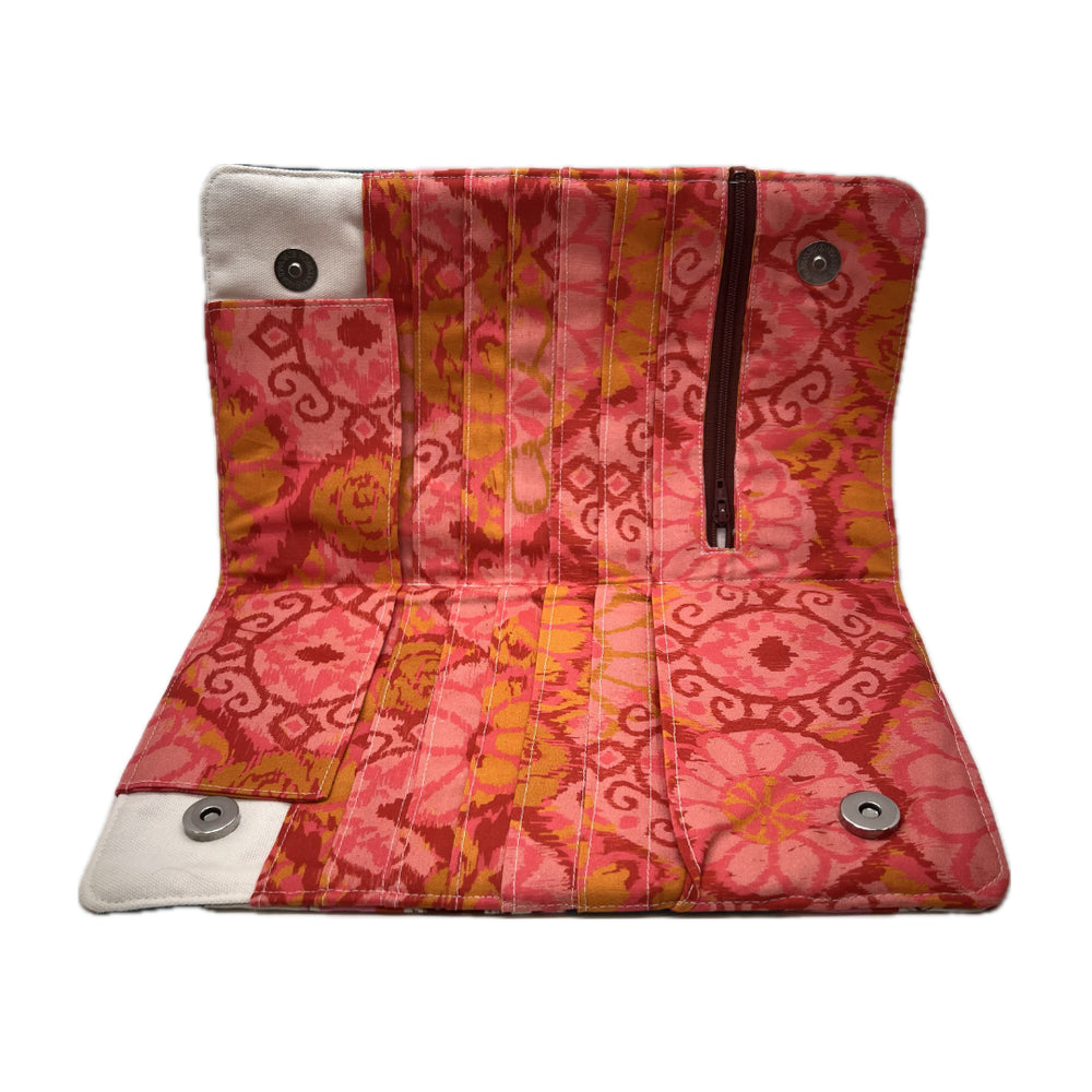 Inside of the needle organizer in a vibrant pink fabric with, red, and orange pattern. 